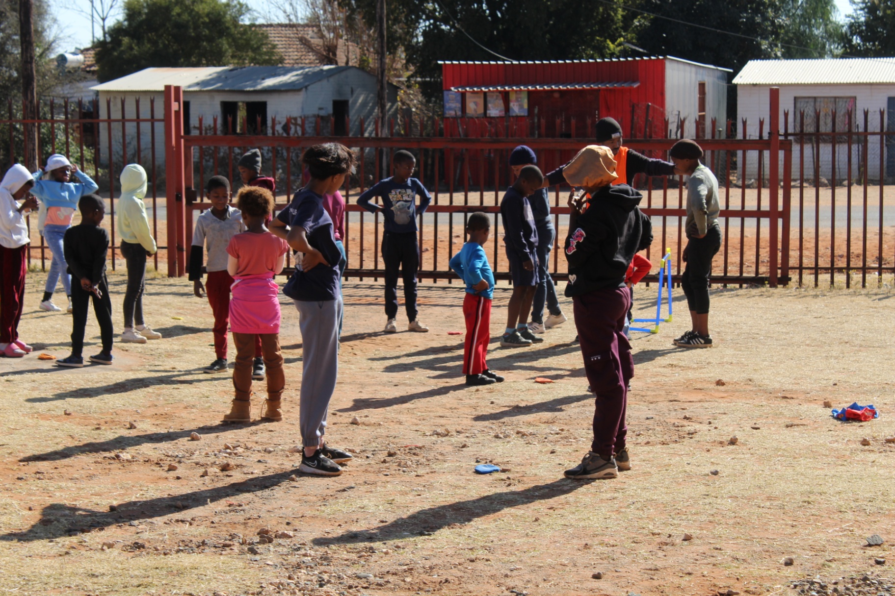 Group of children spread out for a movement game in the yard at a Come N Play outreach